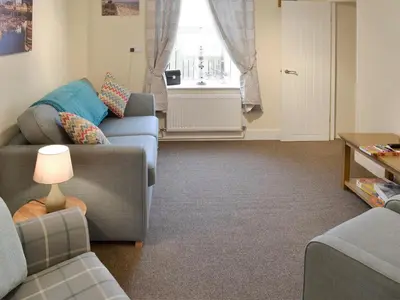 a living room with two couches and a window at Montrose in New Quay