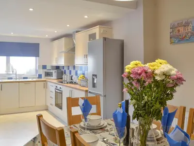 a kitchen with a table with flowers on it at Montrose in New Quay