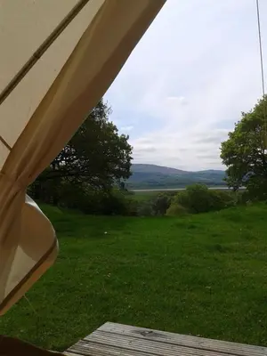 a view of a field from the inside of a tent at Cefn Crib Glamping in Machynlleth