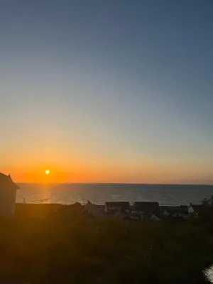 a sunset over the ocean with the sun setting at The Pod & Cwtch luxury accommodation in Aberaeron