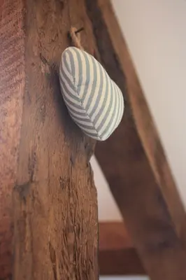 a white and black shell hanging from a wooden beam at Delfryn Cottage in Rhayader