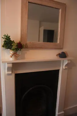 a mirror on top of a fireplace with a mirror over it at Delfryn Cottage in Rhayader