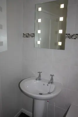 a white sink in a bathroom with a mirror at Delfryn Cottage in Rhayader