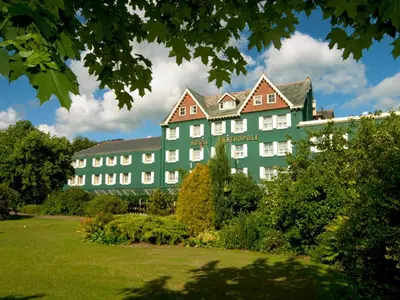 a large green building with a garden in front of it at Metropole Hotel and Spa in Llandrindod Wells
