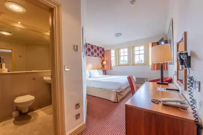 a hotel room with a bed and a bathroom at Metropole Hotel and Spa in Llandrindod Wells