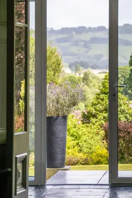 an open door with a vase with purple flowers in it at The Falcondale Country House Hotel in Lampeter