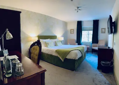 a hotel room with a bed and a desk and a room at The Falcondale Country House Hotel in Lampeter