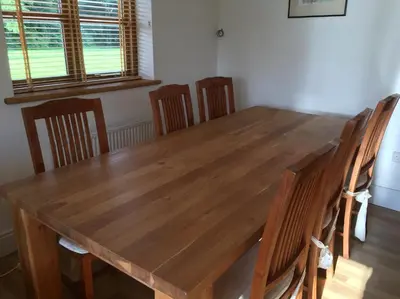 a wooden table and chairs in a room at Maesbury Riverside in Oswestry
