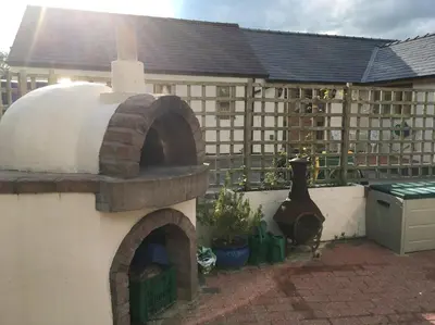 an outdoor pizza oven in front of a building at Maesbury Riverside in Oswestry