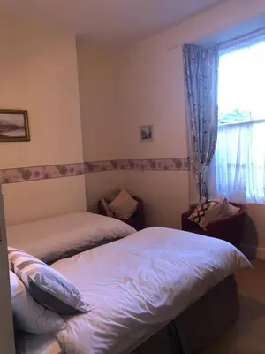 a bedroom with two beds and a window at The Sandpiper in Barmouth