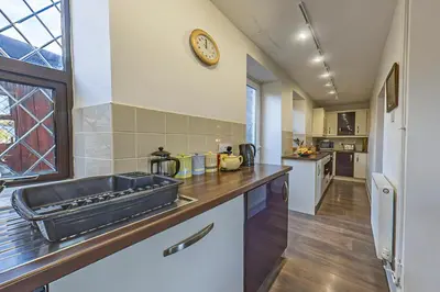 a kitchen with a sink and a clock on the wall at Gwynfryn in Cerrig-y-Druidion