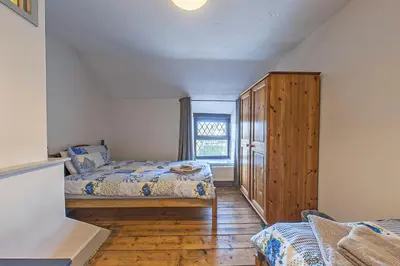 a bedroom with two beds and a wooden cabinet at Gwynfryn in Cerrig-y-Druidion