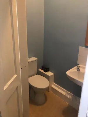 a bathroom with a white toilet and a sink at Leamington House in Barmouth