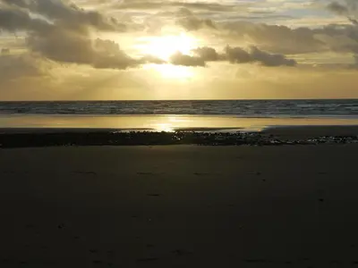 a sunset on the beach with the ocean in the background at Seascape in Barmouth