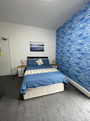 a bedroom with a large blue painting on the wall at Seascape in Barmouth