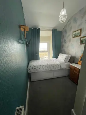 a small bedroom with a bed and a window at Seascape in Barmouth