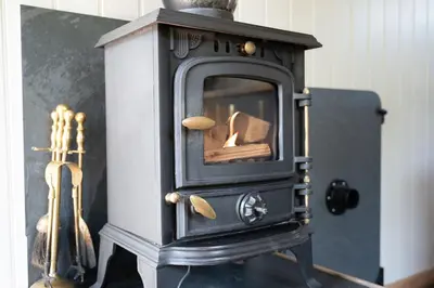 an old black stove with some wood in it at Cegir Escapes in Darowen