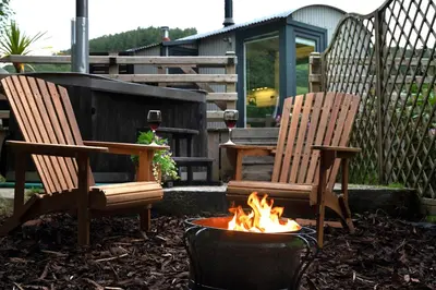 two chairs and a fire pit in a yard at Cegir Escapes in Darowen
