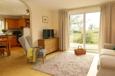 a kitchen and living room with a television and a living room at Pheasant Walk at Eaton Manor in Church Stretton