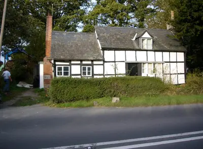a white and black house on the side of a road at Chestnut Cottage in Eardisley