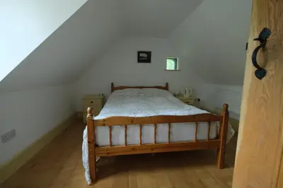 a small bedroom with a bed in a attic at Chestnut Cottage in Eardisley