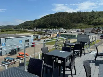 a patio with tables and chairs on a balcony at Sea retreat caravans in Aberystwyth