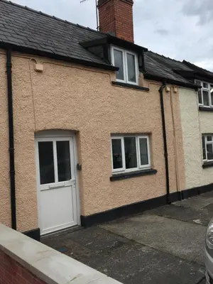 a brick house with a white door and windows at March Cottage Brecon in Brecon