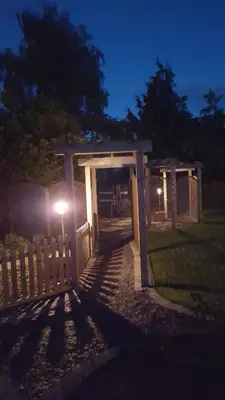 a fence with a gate with a light at night at Ruth's Rest Country Retreat with private Hot Tub & Views of Open Countryside in Shrewsbury
