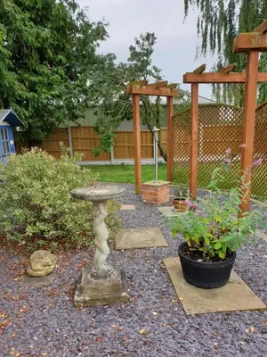 a garden with a bird bath and a wooden pergola at Ruth's Rest Country Retreat with private Hot Tub & Views of Open Countryside in Shrewsbury