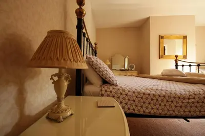 a bedroom with a bed and a table with a lamp at Fitzwarine House Whittington in Whittington