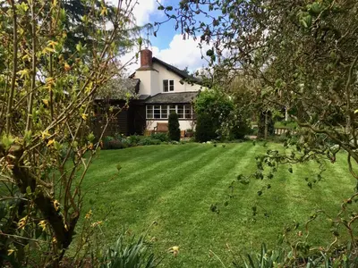 a house with a large yard with green grass at Yew Tree Cottage in Leominster