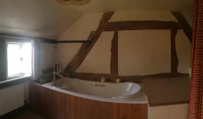a bathroom with a white tub and a window at Yew Tree Cottage in Leominster