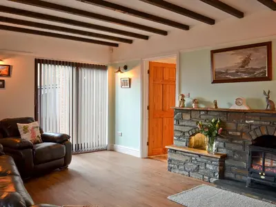 a living room with a couch and a stone fireplace at Dyffryn Haidd in Llanafan