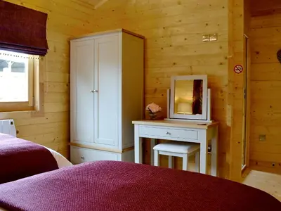 a bedroom with a desk and a cabinet with a mirror at Ty Pren in Dyffryn