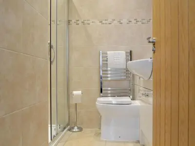a bathroom with a toilet and a glass shower at Llys yr Wylan in Aberystwyth