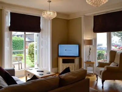 a living room with a couch and a tv at Llys yr Wylan in Aberystwyth
