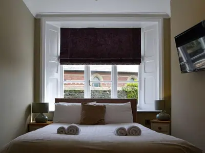 a bedroom with a bed with two towels on it at Llys yr Wylan in Aberystwyth