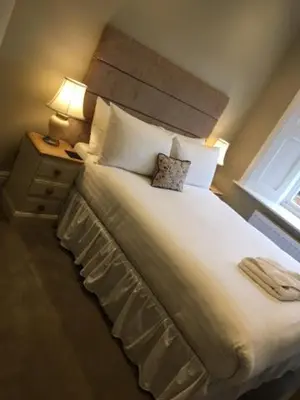 a bedroom with a large white bed with a window at Llys yr Onnen in Aberystwyth