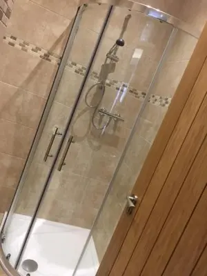 a shower with a glass door in a bathroom at Llys yr Onnen in Aberystwyth