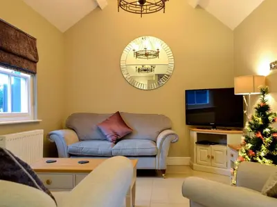a living room with a couch and a christmas tree at Llys Celyn - Holly Farm in Aberystwyth