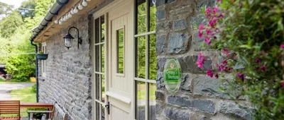 a brick building with a door and a window at Drovers Retreat in Llandrindod Wells