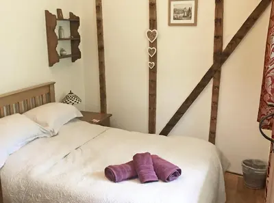 a white bed with two purple towels on it at Drovers Retreat in Llandrindod Wells