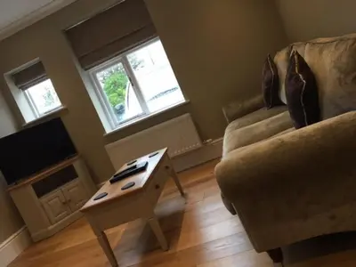 a living room with a couch and a coffee table at Llys y Barnwr - Judge's Court in Aberystwyth