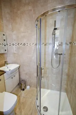 a bathroom with a shower and a toilet and a sink at Llys y Barnwr - Judge's Court in Aberystwyth
