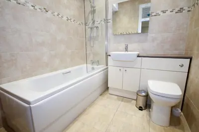 a bathroom with a sink and a toilet and a bath tub at Llys y Barnwr - Judge's Court in Aberystwyth