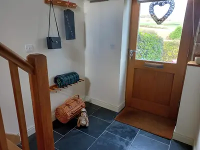 a hallway with a door and a suitcase on the floor at The Barn at Titley in Kington