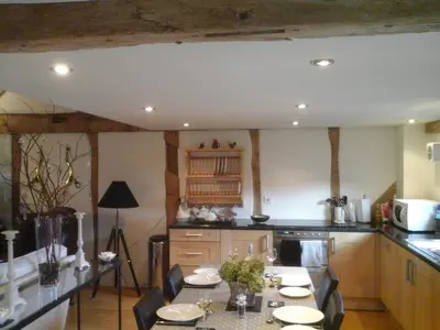 a kitchen with a table with chairs in it at The Barn at Titley in Kington