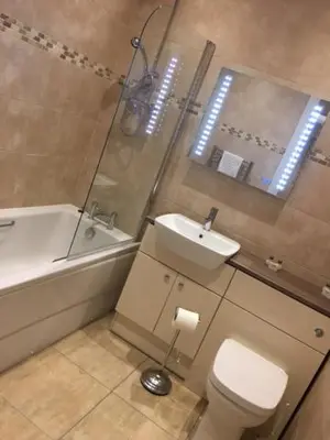 a bathroom with a sink and a toilet and a bath tub at Llys y Dderwen - Oak Court in Aberystwyth
