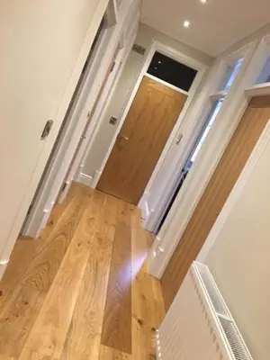 a hallway with a door and a wooden floor at Llys y Dderwen - Oak Court in Aberystwyth