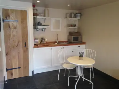 a kitchen with a table and chairs and a sink at The Queens in Ludlow